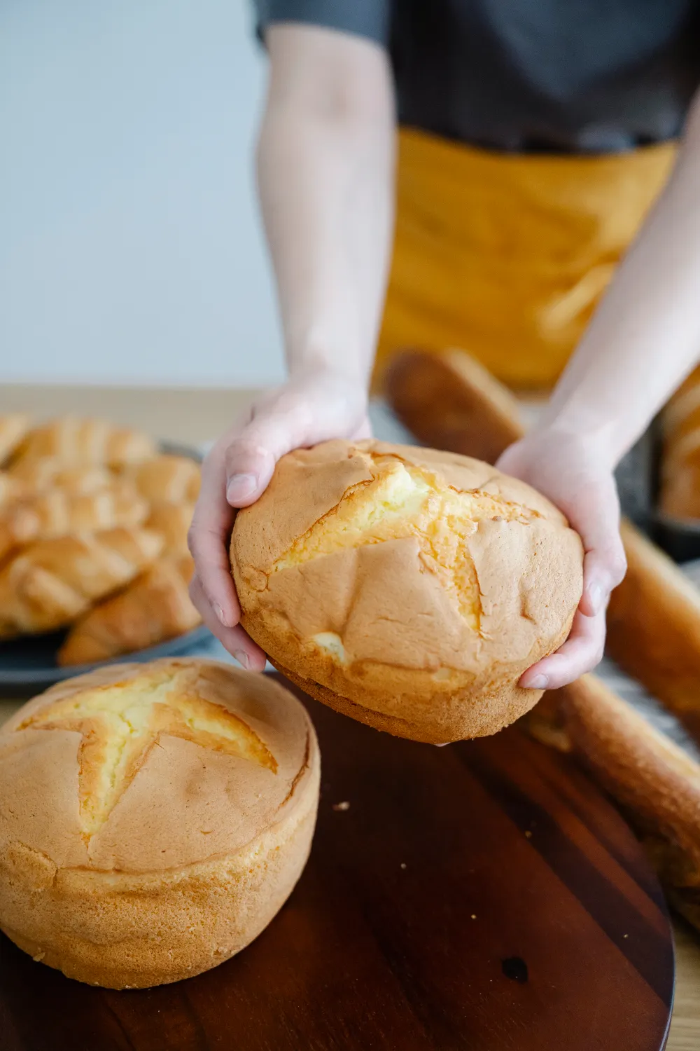 Baker holding a fresh loaf