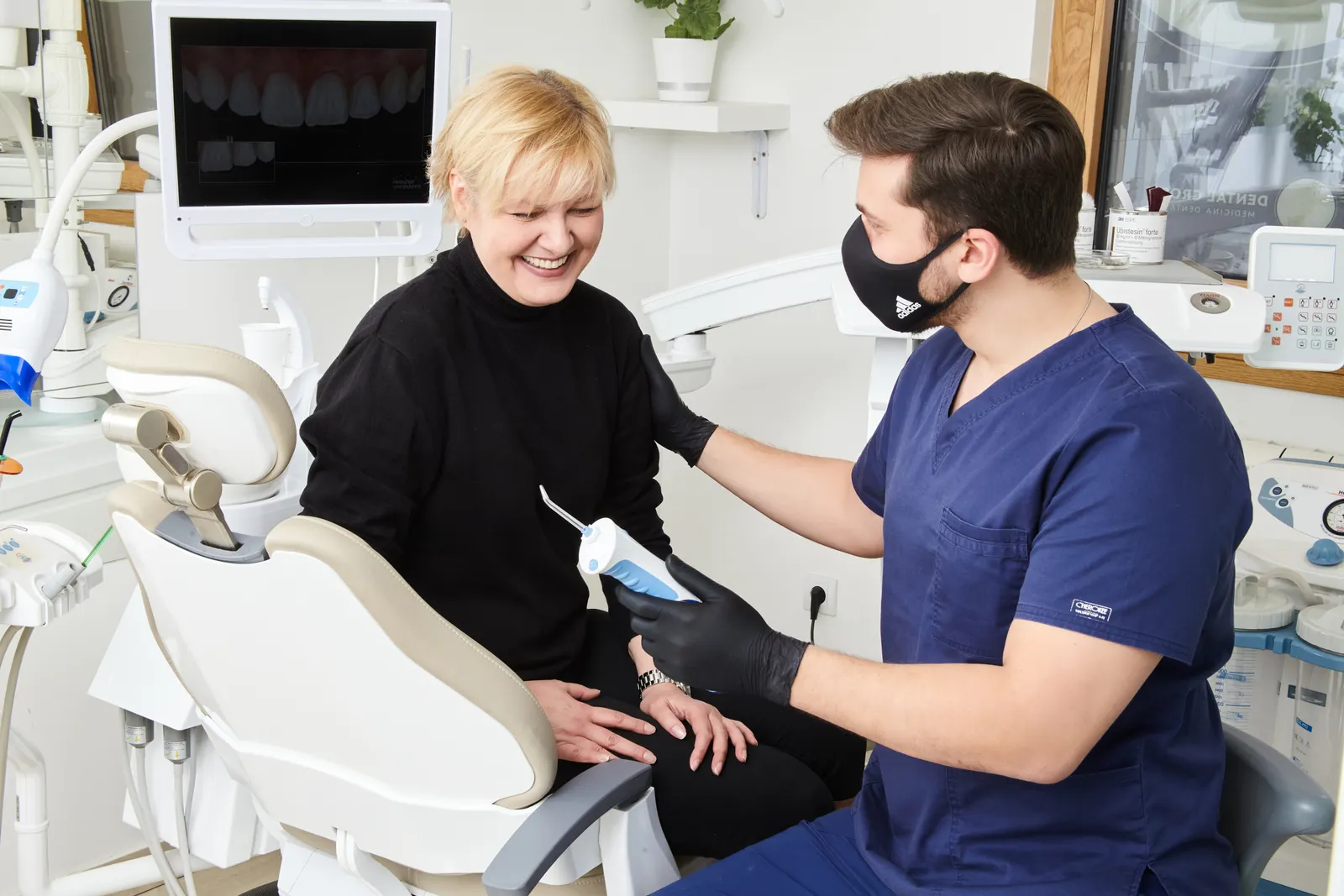 Dentist chatting with a smiling patient