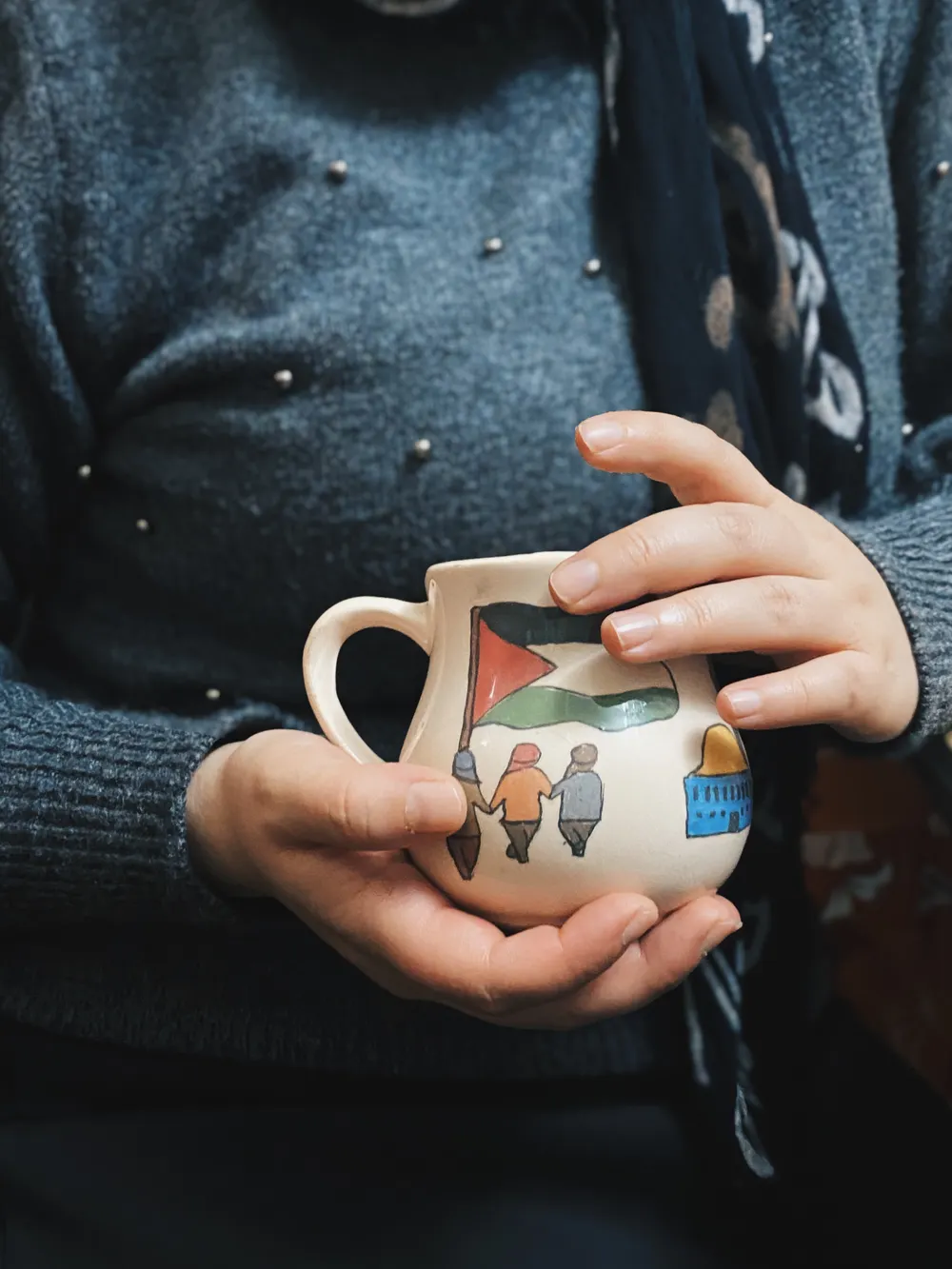 Hands holding a hand-painted mug