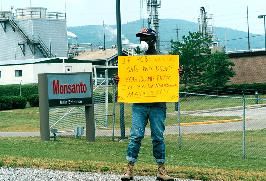 Activist Herman Frazier protests in front of a Monsanto Plant. Via The Anniston Star. 