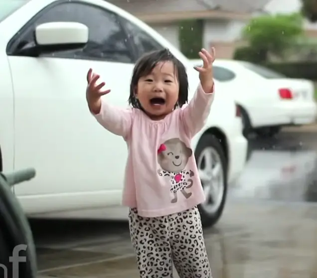 Little girl experiences rain for the first time. 